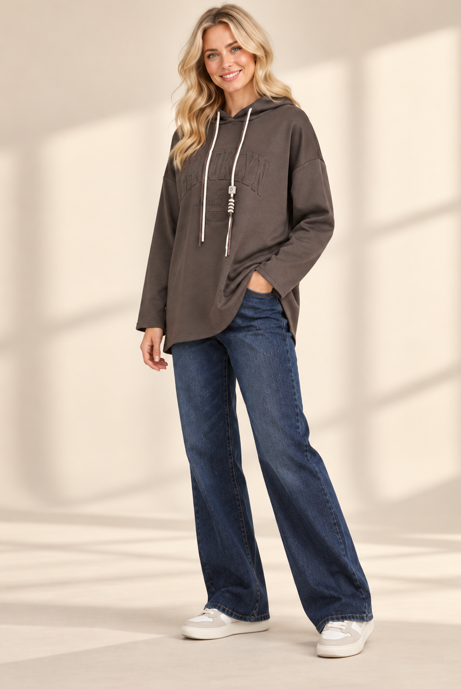 Brun hoodie Brooklyn i längre oversized modell med ton-i-ton-text framtill, huva, kontrasterande dragsnören och långa ärmar med nedhasad axel