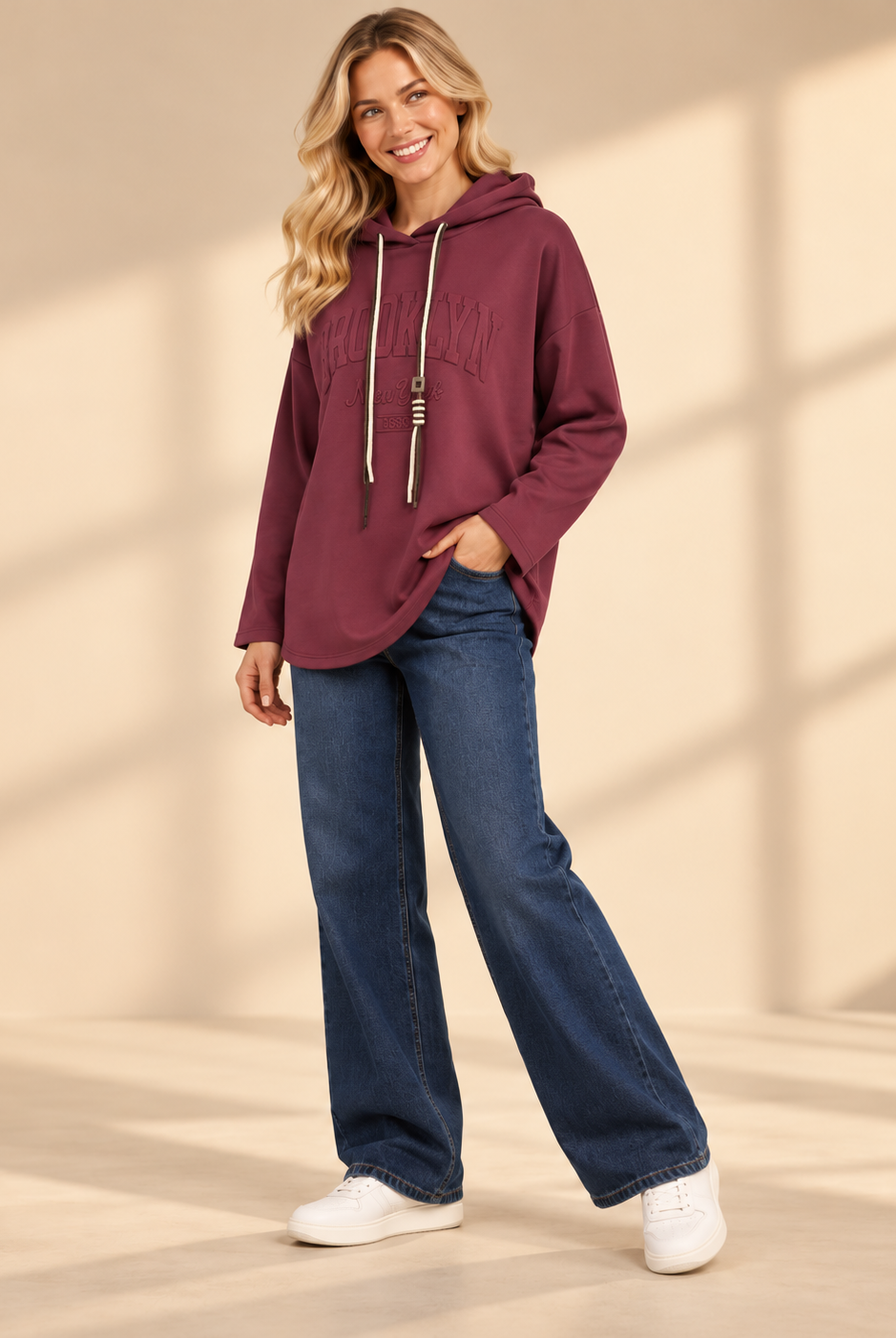 Vinröd hoodie Brooklyn i längre oversized modell med ton-i-ton-text framtill, huva, kontrasterande dragsnören och långa ärmar med nedhasad axel.