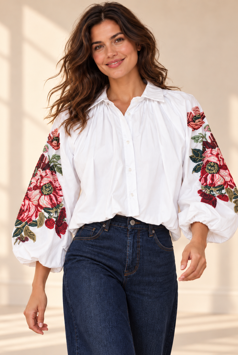 Vit blus Klara med vida ballongärmar, rosa och röda blommotiv, skjortkrage och ledig passform, visad på modell
