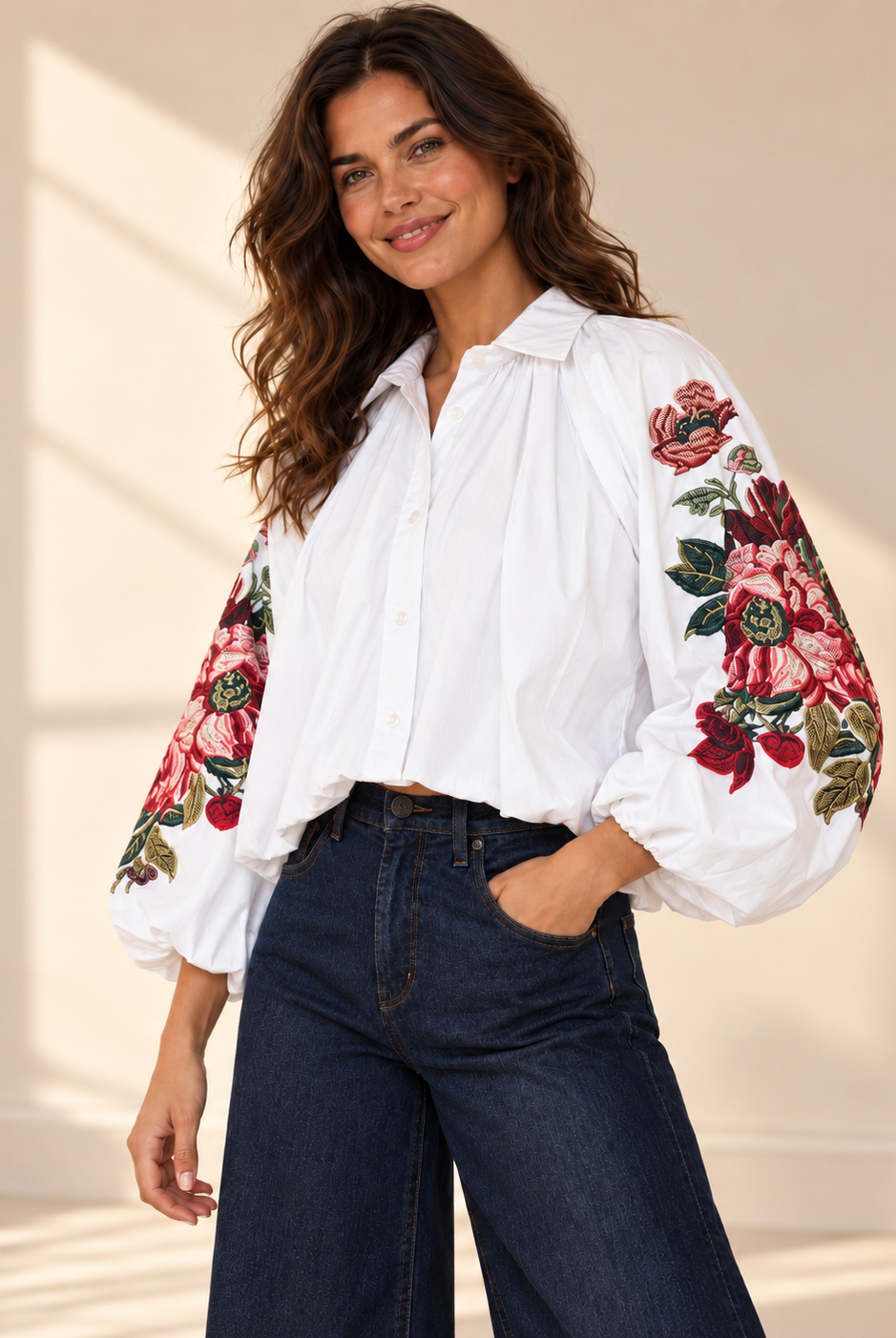 Vit blus Klara med vida ballongärmar, rosa och röda blommotiv, skjortkrage och ledig passform, visad på modell