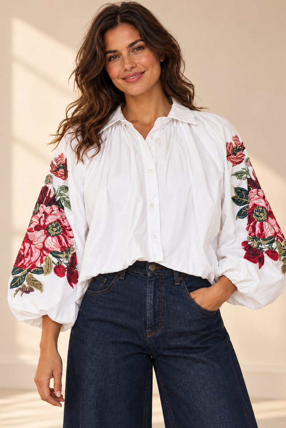 Vit blus Klara med vida ballongärmar, rosa och röda blommotiv, skjortkrage och ledig passform, visad på modell