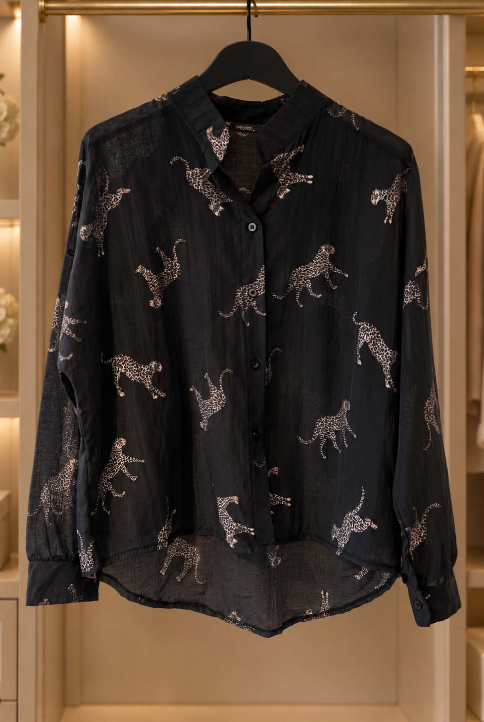Svart, lätt transparent blus Lollo Gepard med ljusa kattdjursmotiv, långa ärmar med manschetter och rundad nederkant.