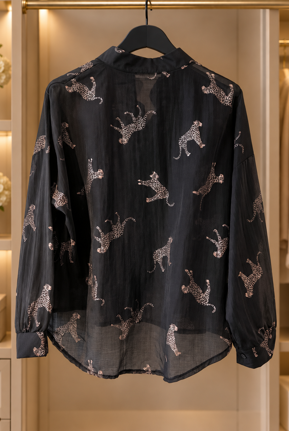Svart, lätt transparent blus Lollo Gepard med ljusa kattdjursmotiv, långa ärmar med manschetter och rundad nederkant.