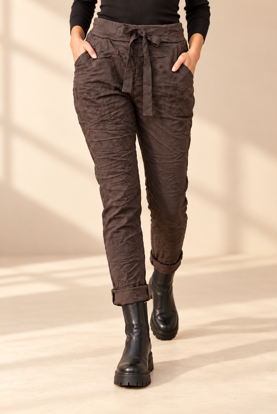 Joggers Abstrakt i brunt med diskret ton-i-ton-mönster, elastisk midja, dragsko och sidofickor, visade på modell