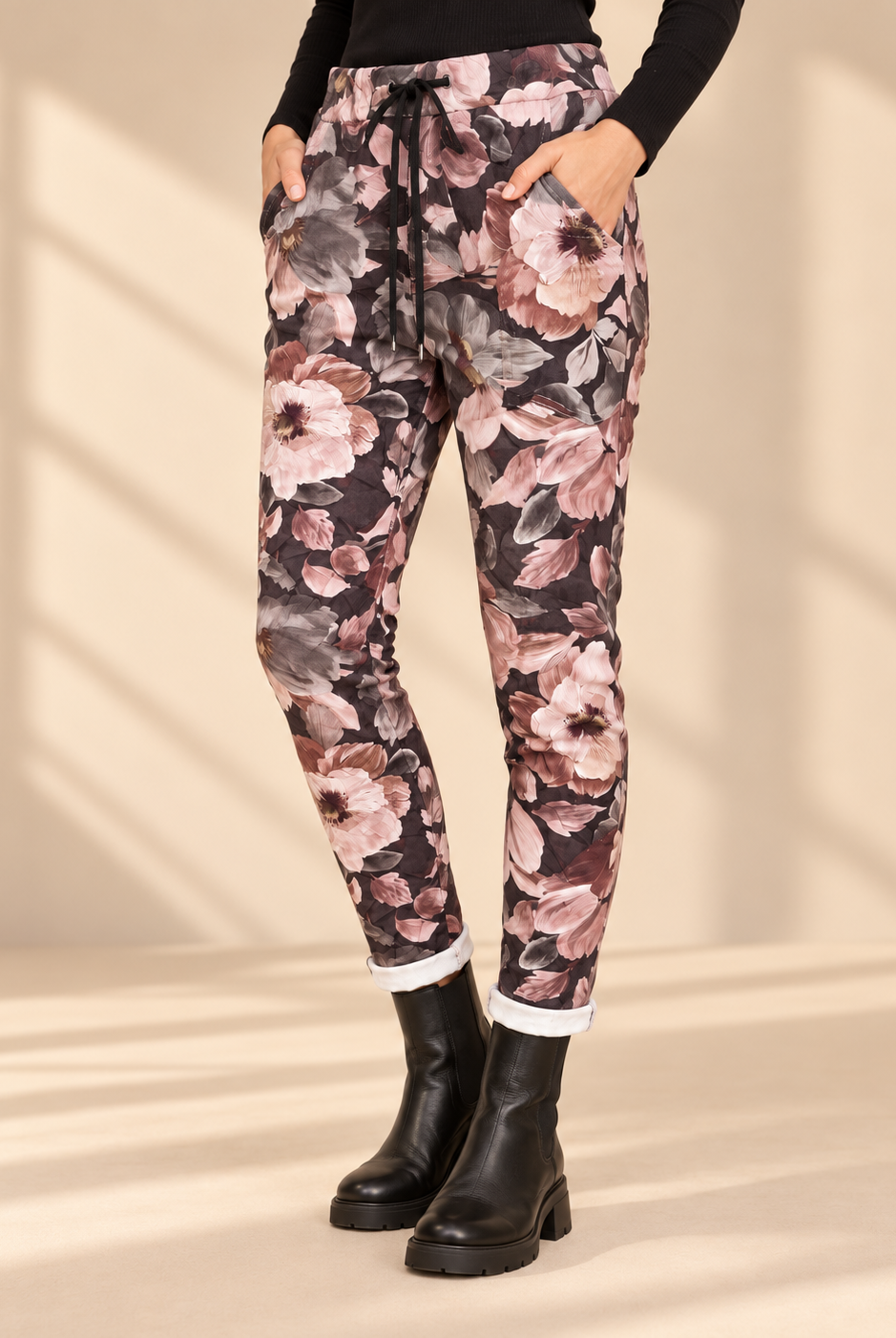 Joggers Blomster i mokkabrun med stora blommor i rosa, beige och grå toner, avsmalnande ben och uppvikta benslut