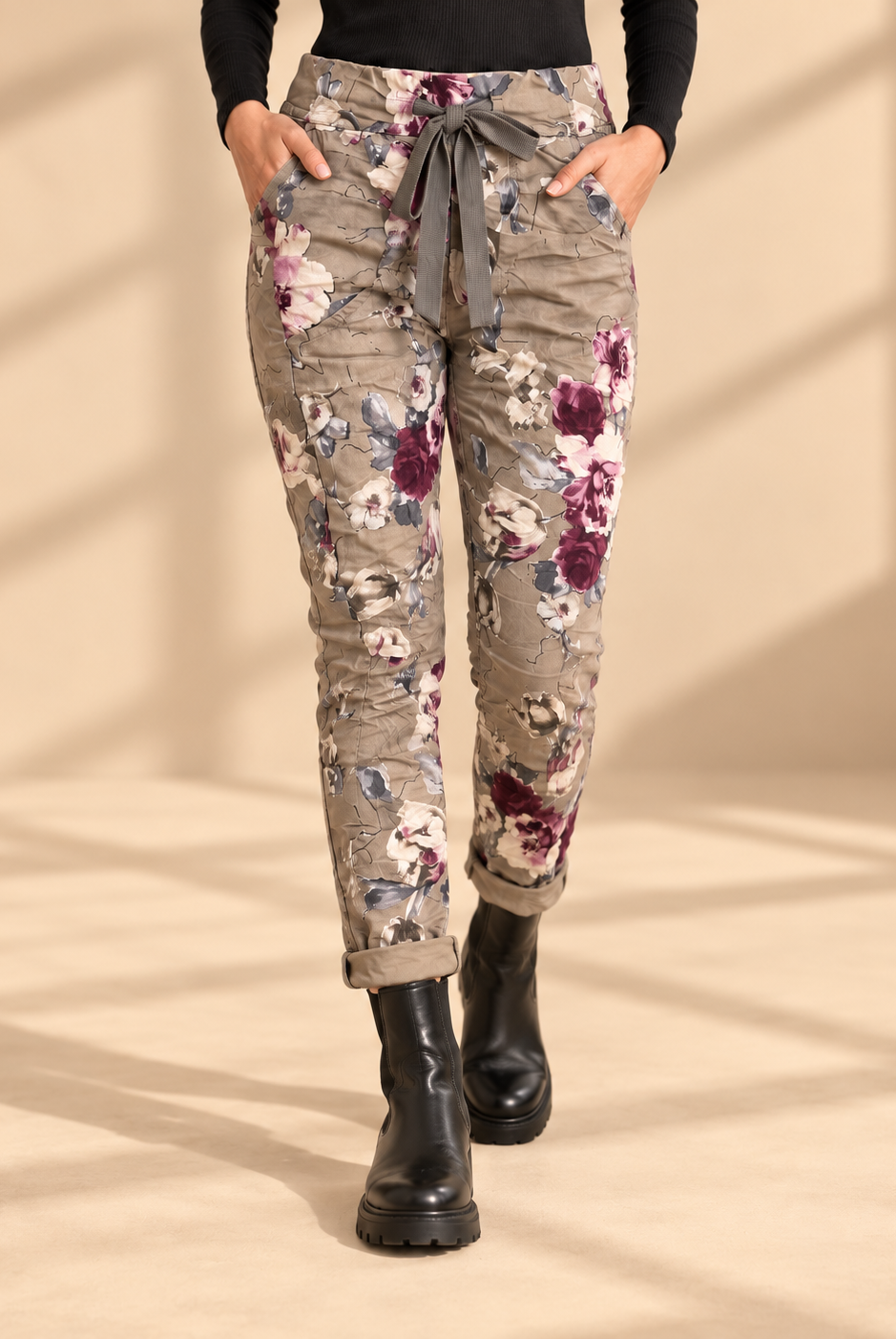 Joggers Blomster Fungo med blommönster, elastisk midja, dragsko och sidofickor, visade på modell med uppvikta benslut.