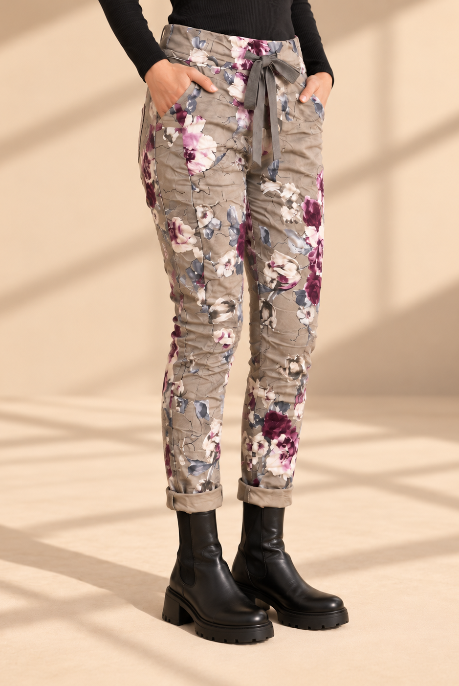 Joggers Blomster Fungo med blommönster, elastisk midja, dragsko och sidofickor, visade på modell med uppvikta benslut.