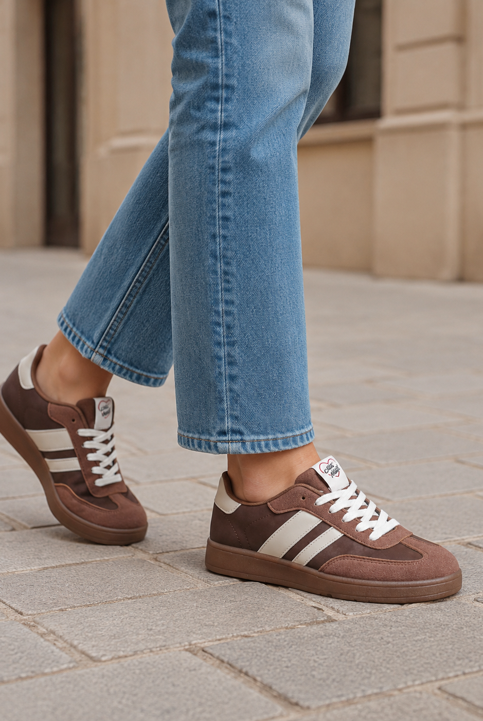 Bruna damsneakers med beige ränder och brun sula under promenad
