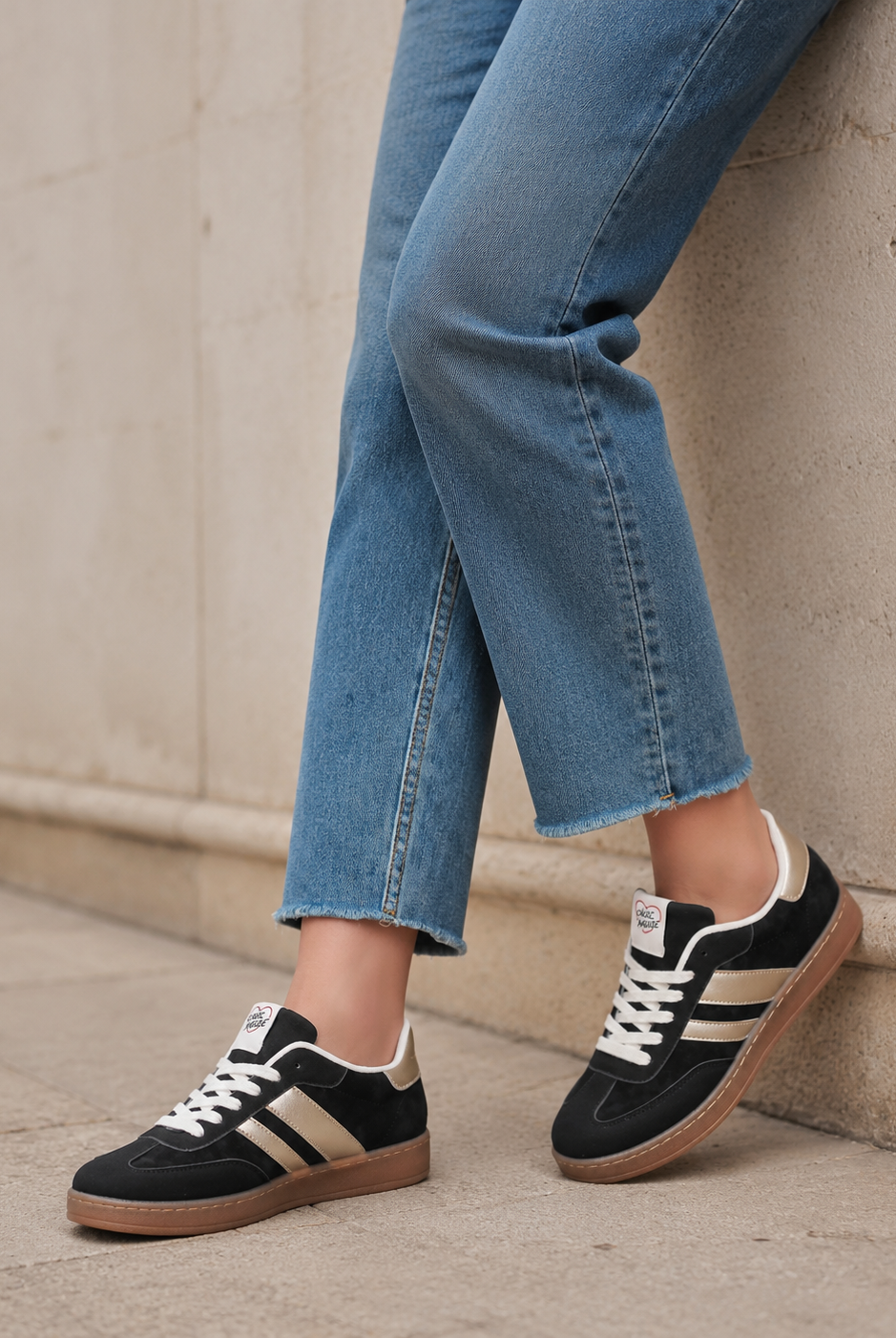 Svarta retro sneakers med ljusa metallicdetaljer stylade med jeans