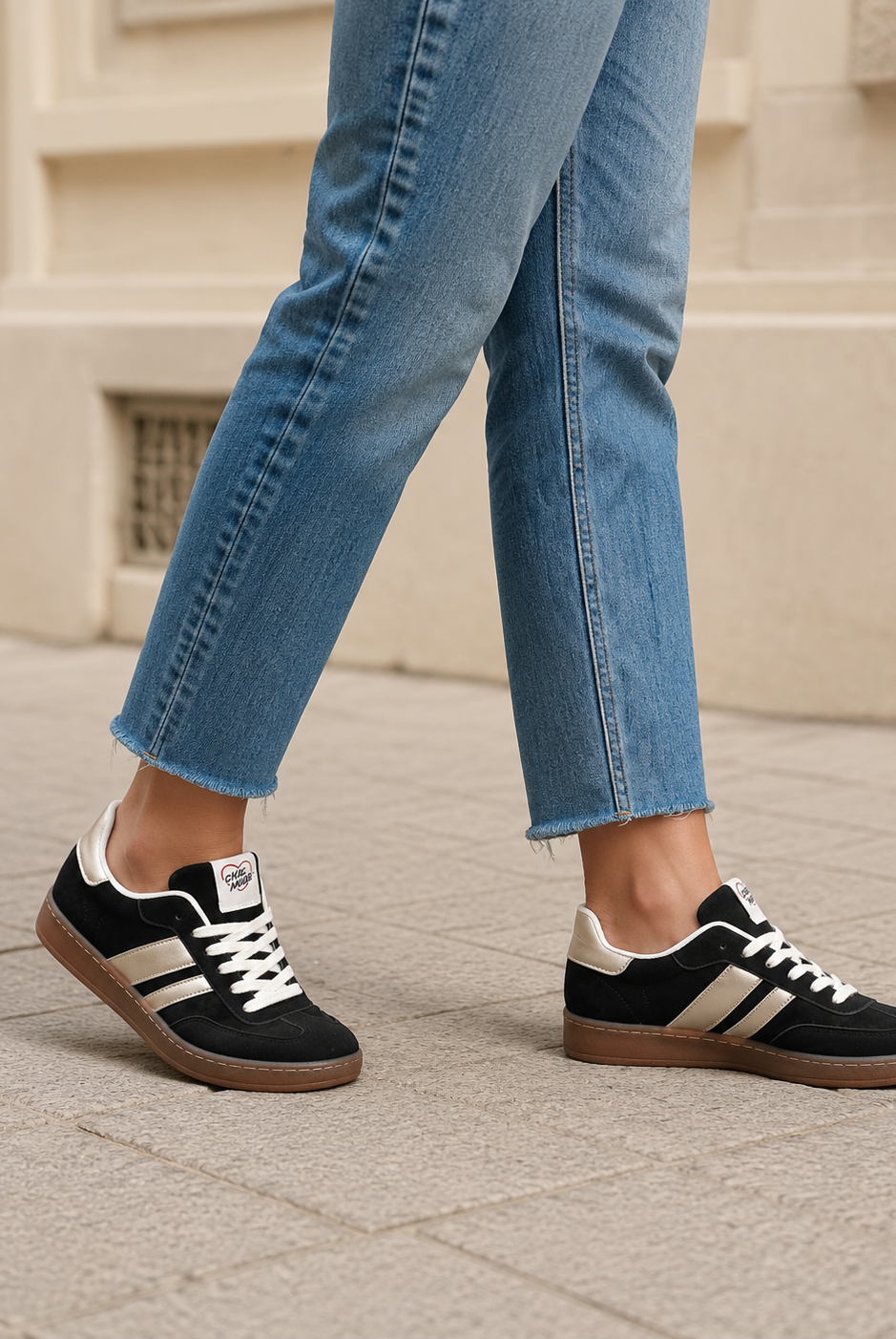 Svarta damsneakers med metallicränder och brun sula under promenad