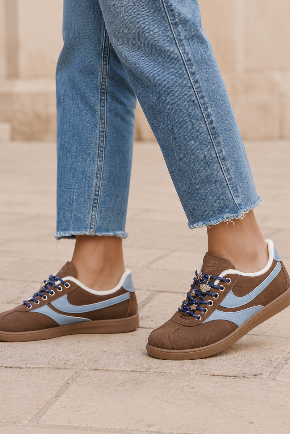 Bruna damsneakers med blå detaljer och smycken i stadsmiljö