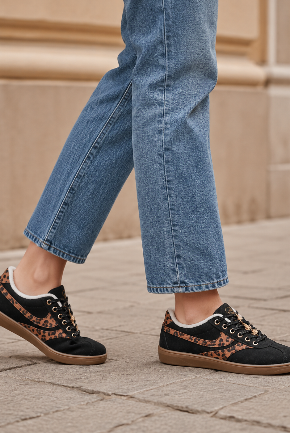 Svarta damsneakers med leomönster och brun gummisula i stadsmiljö