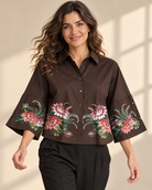 Blus Katinka med skjortkrage, knäppning framtill och tryckta blommor längs nederkanten och på de vida ärmarna