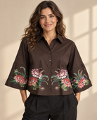 Blus Katinka med skjortkrage, knäppning framtill och tryckta blommor längs nederkanten och på de vida ärmarna
