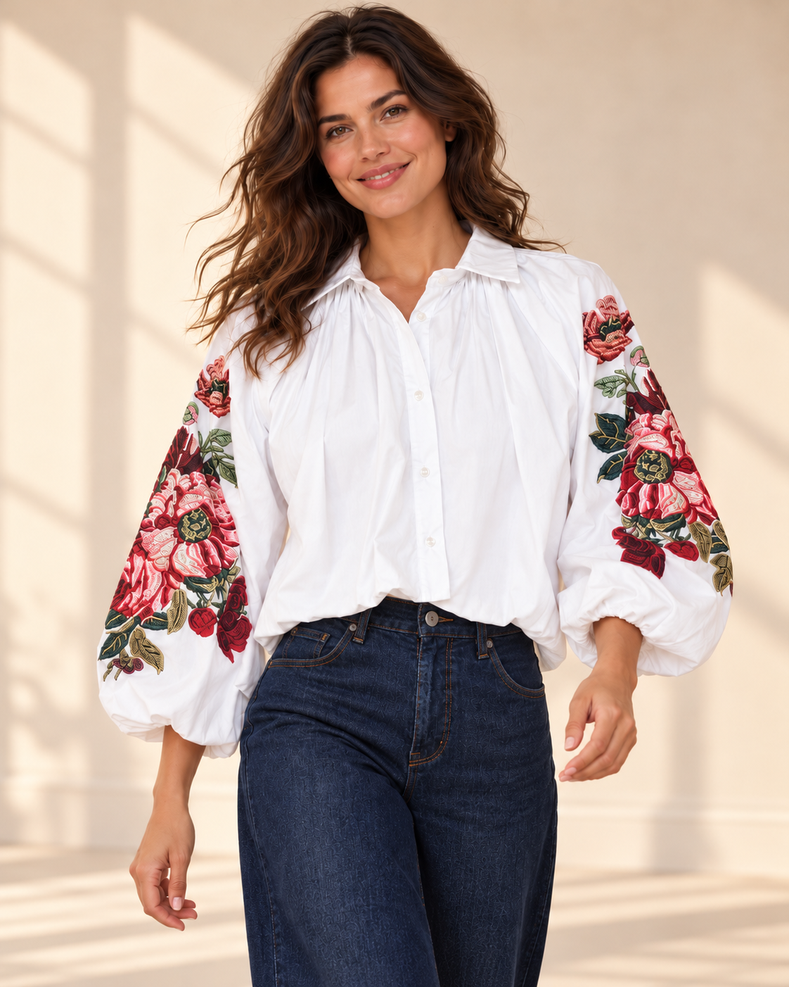 Vit blus Klara med vida ballongärmar, rosa och röda blommotiv, skjortkrage och ledig passform, visad på modell