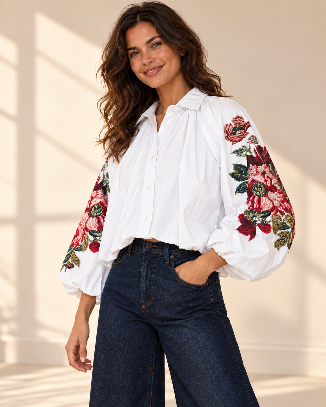 Vit blus Klara med vida ballongärmar, rosa och röda blommotiv, skjortkrage och ledig passform, visad på modell