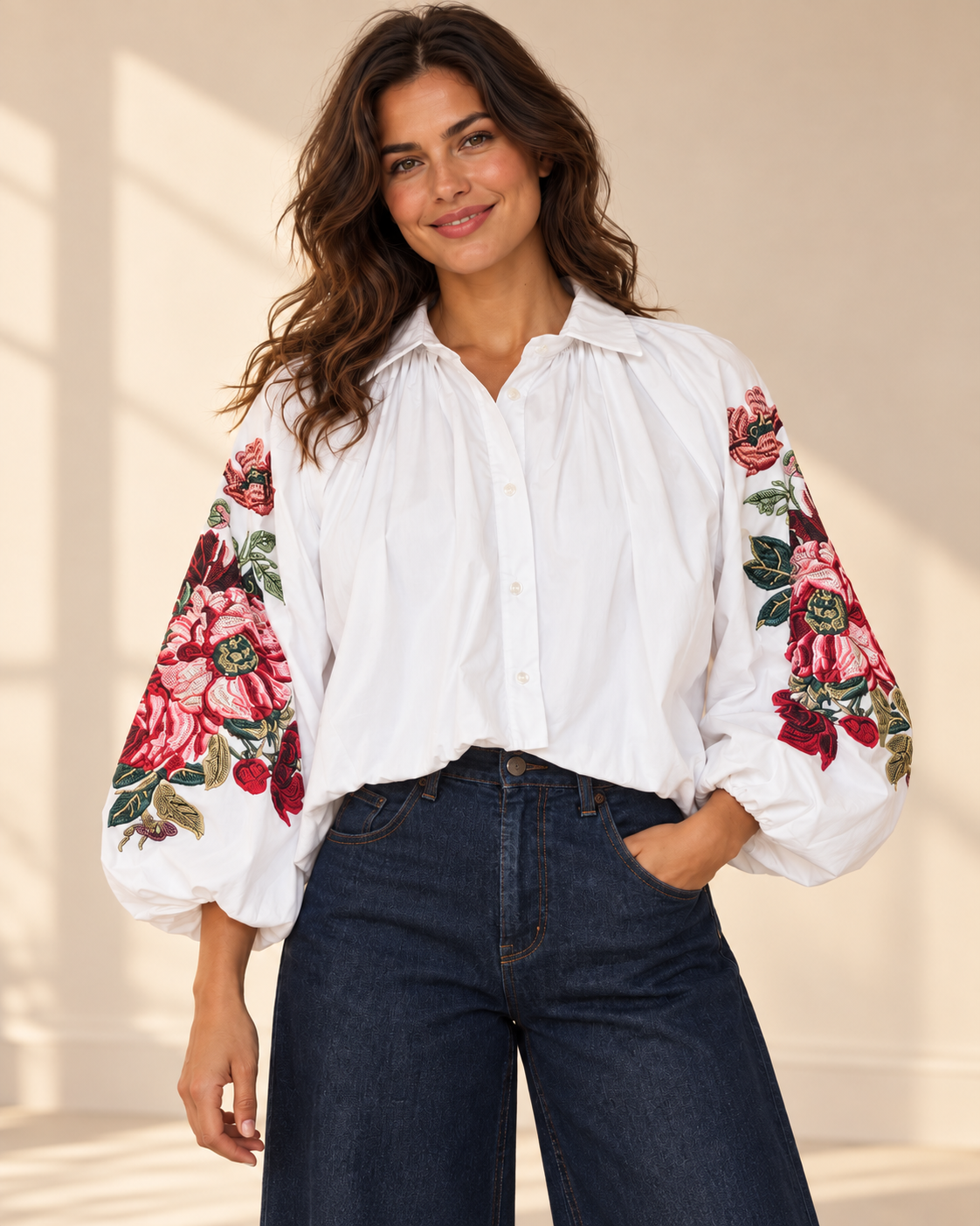 Vit blus Klara med vida ballongärmar, rosa och röda blommotiv, skjortkrage och ledig passform, visad på modell