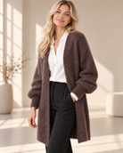 Lång brun mohaircardigan Evelina med öppen front, fluffig stickning och rymliga långa ärmar med ribbstickade muddar, visad på modell.