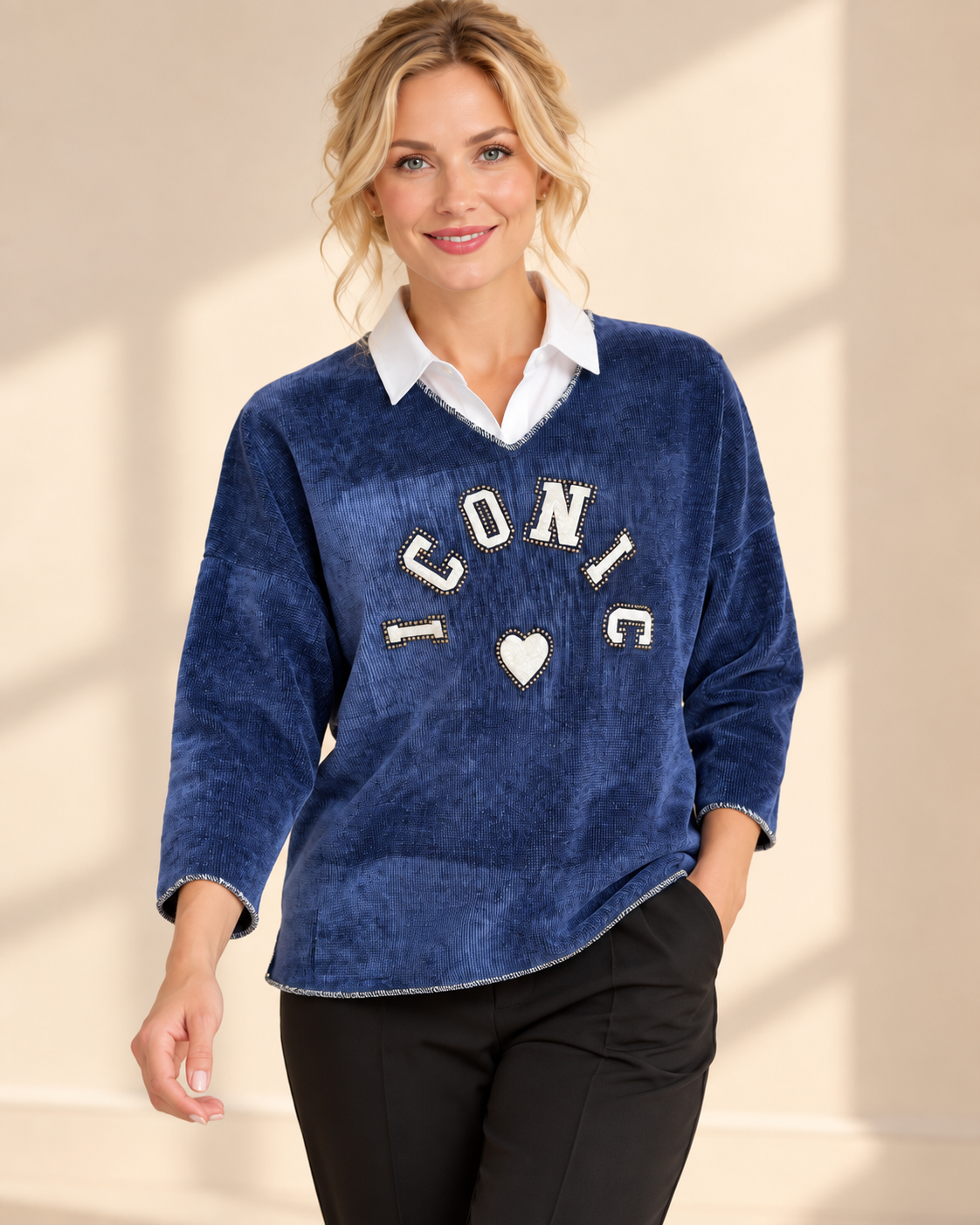 Blaues Iconic-Shirt mit V-Ausschnitt, entspannter Passform und dekorativer Nietenapplikation auf der Vorderseite.