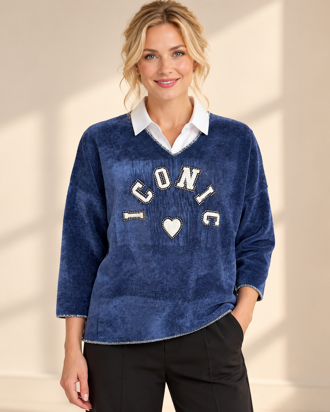 Blaues Iconic-Shirt mit V-Ausschnitt, entspannter Passform und dekorativer Nietenapplikation auf der Vorderseite.