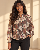 Transparent blus Lollo Blomster i brunt med stora beige och bruna blommor, vinröda blommittar, skomakarkrage och långa ärmar med manschett.