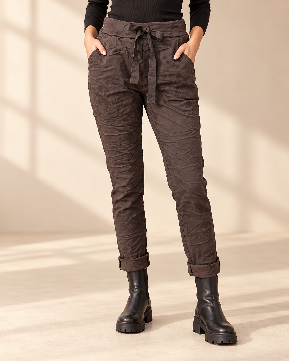 Joggers Abstrakt i brunt med diskret ton-i-ton-mönster, elastisk midja, dragsko och sidofickor, visade på modell