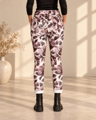 Joggers Blomster med storblommigt mönster på ljus botten, avsmalnande ben och uppvikta benslut, visade på modell.
