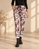Joggers Blomster med storblommigt mönster på ljus botten, avsmalnande ben och uppvikta benslut, visade på modell.
