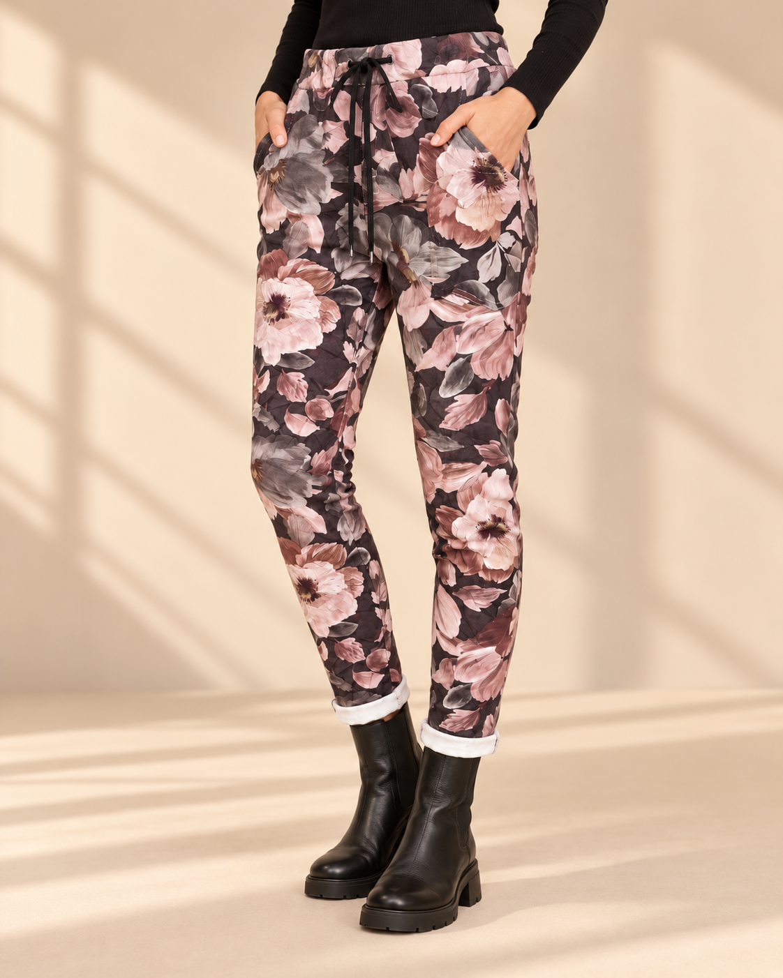 Joggers Blomster i mokkabrun med stora blommor i rosa, beige och grå toner, avsmalnande ben och uppvikta benslut
