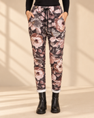 Joggers Blomster i mokkabrun med stora blommor i rosa, beige och grå toner, avsmalnande ben och uppvikta benslut