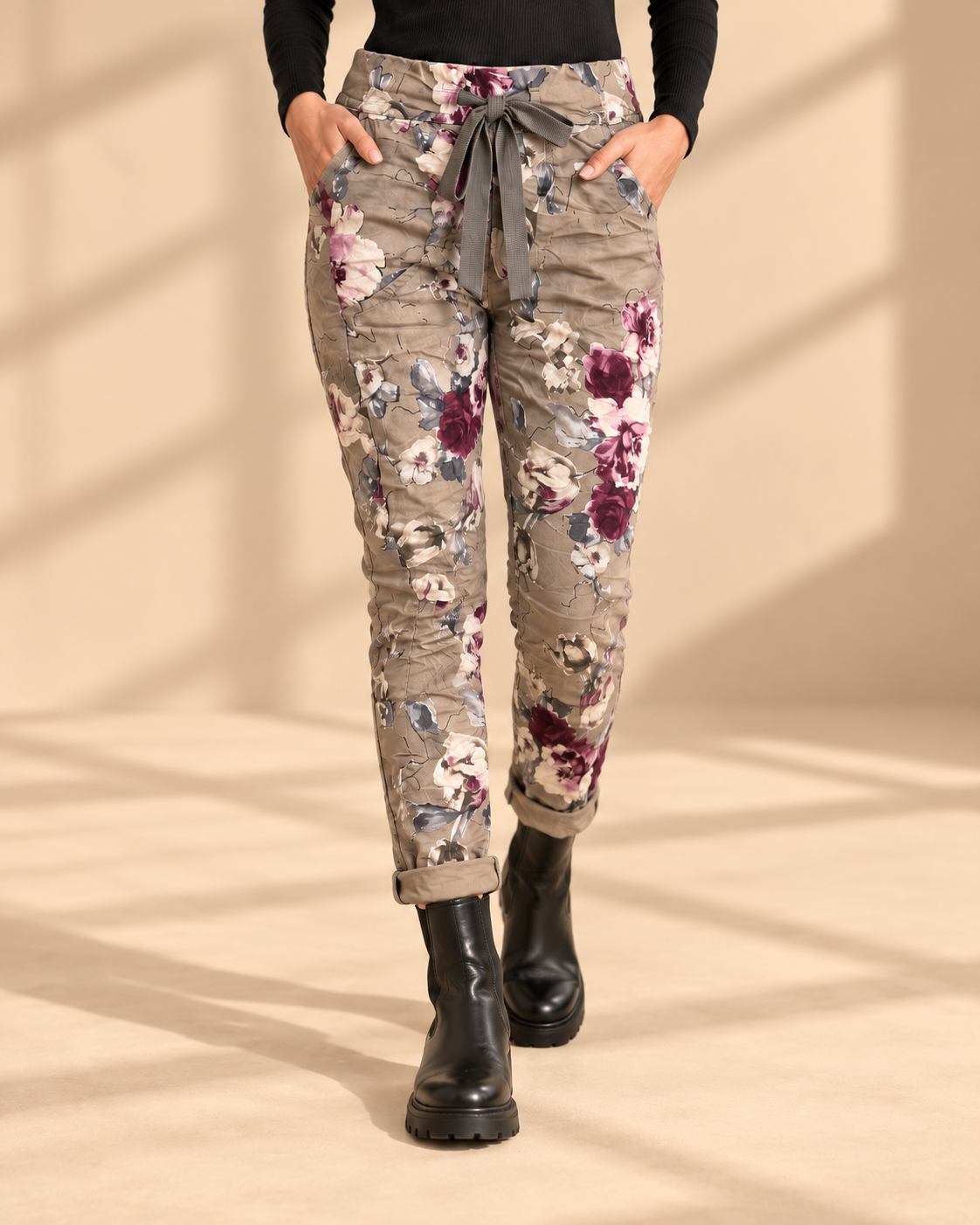 Joggers Blomster Fungo med blommönster, elastisk midja, dragsko och sidofickor, visade på modell med uppvikta benslut.