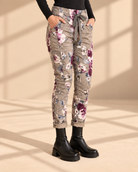 Joggers Blomster Fungo med blommönster, elastisk midja, dragsko och sidofickor, visade på modell med uppvikta benslut.
