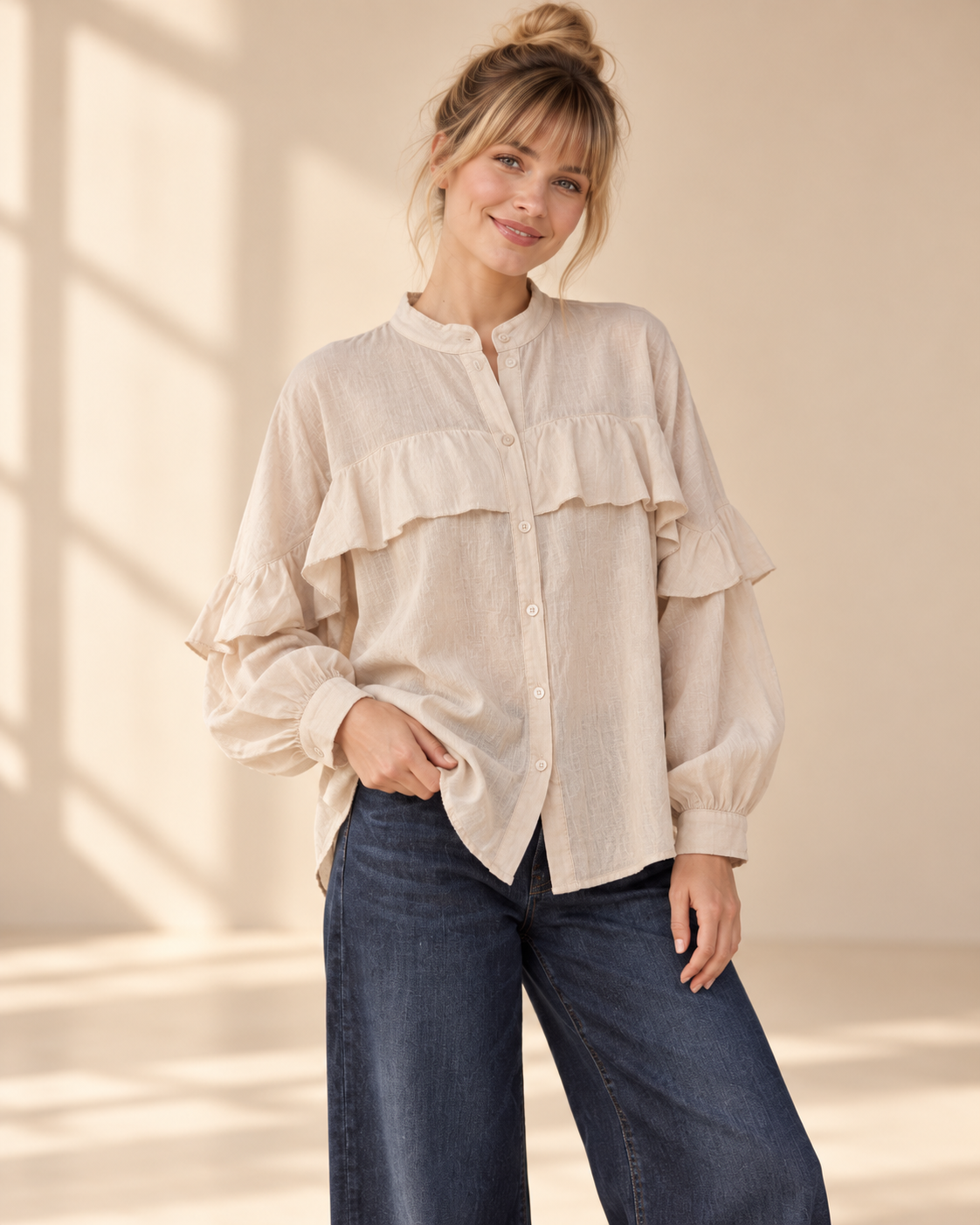 Beige bomullsblus Rosalie med ståkrage, knappar framtill, volangdetaljer och långa, vida ärmar med manschetter
