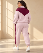 Zipjacka Mira i ljusrosa med vinröd V-formad panel över bröst och axlar, hög krage, dragkedja framtill och ledig passform.