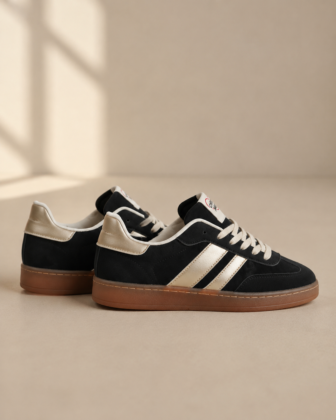 Svarta damsneakers Chicmuse med metallicdetaljer och brun gummisula från sidan